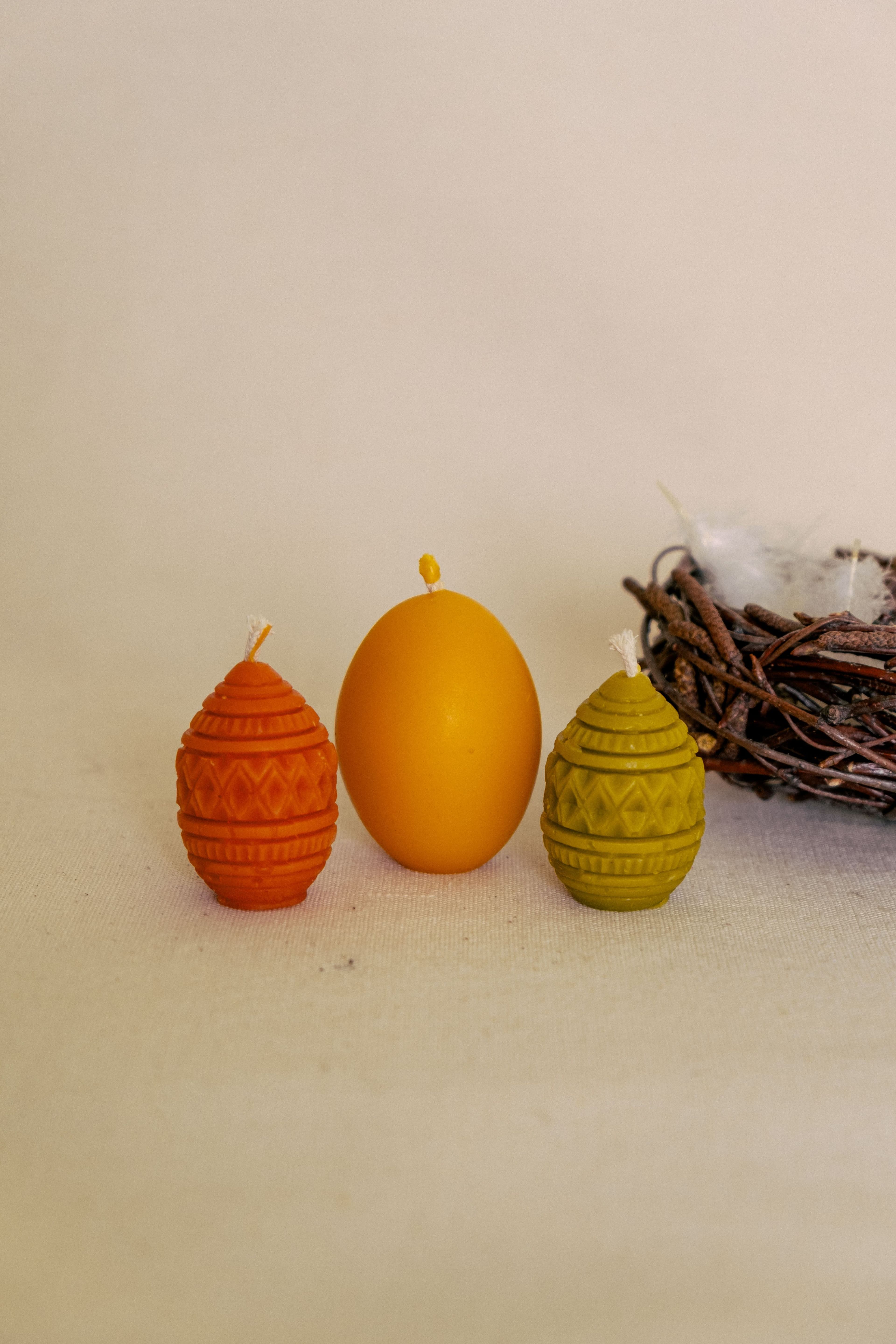 Набір яєчок в корзинці з березових гілочок та дві свічечки